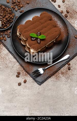 Klassisches Tiramisu Dessert auf Keramikplatte auf Betongrund Stockfoto
