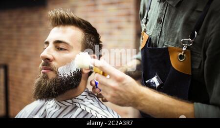 Kunden bei Bart rasieren im Friseurladen Stockfoto