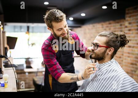 Barbier rasieren einen bärtigen Mann in einen Friseurladen, Nahaufnahme Stockfoto
