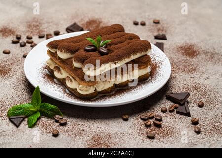 Klassisches Tiramisu Dessert auf Keramikplatte auf Betongrund Stockfoto
