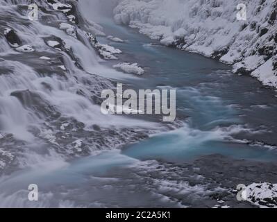 Der Wasserlauf der Gullfoss Wasserfall in Island mit Schnee Stockfoto