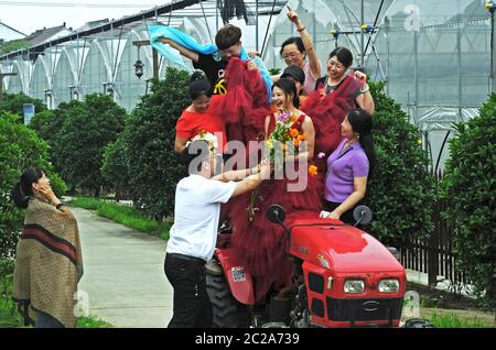 Huzhou, Chinas Provinz Zhejiang. Juni 2020. Ein Bräutigam (2. L, Vorderseite) schenkt seiner Braut (3. L, Vorderseite) Blumen in einem Öko-Park im Nanxun Bezirk Huzhou, Ostchina Zhejiang Provinz, 16. Juni 2020. Der Park nutzt seine Umgebung, hat viele malerische Orte mit romantischer Atmosphäre gebaut und eine einzigartige Hochzeitsindustrie entwickelt. Quelle: Tan Jin/Xinhua/Alamy Live News Stockfoto