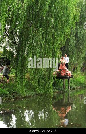 Huzhou, Chinas Provinz Zhejiang. Juni 2020. Ein Paar posiert für Hochzeitsfotos in einem Öko-Park im Nanxun Bezirk in Huzhou, Ostchina Zhejiang Provinz, 16. Juni 2020. Der Park nutzt seine Umgebung, hat viele malerische Orte mit romantischer Atmosphäre gebaut und eine einzigartige Hochzeitsindustrie entwickelt. Quelle: Tan Jin/Xinhua/Alamy Live News Stockfoto