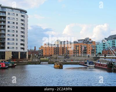 Blick auf die Schleusentore am leeds Dock mit einem gelben Wassertaxi und Hausbooten, die am Dock festgemacht sind Stockfoto