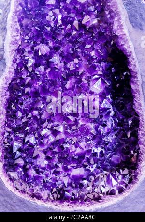 Amethyst purpurner Kristall. Mineralkristalle in der natürlichen Umgebung. Textur aus edlem und halbschädlicher Edelstein Stockfoto