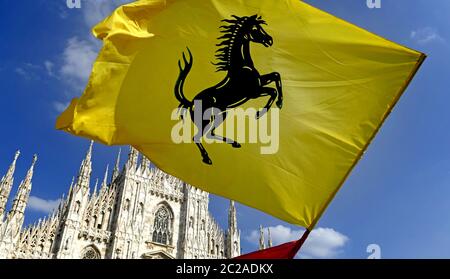 Ferrari-Fans winken eine Ferrari-Flagge in Duomo Platz, um den 90. Jahrestag des Ferrari , in Mailand zu feiern. Stockfoto