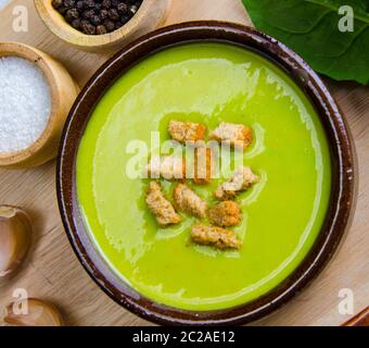 Spinat-Suppe serviert auf Holzbrett Stockfoto