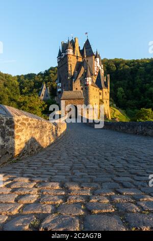 Brücke, die zur Burgtür bei Burg Eltz führt, die von grünen Bergen in Deutschland umgeben ist. Stockfoto