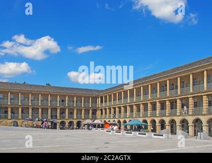 Menschen sitzen in Cafés und Einkaufen auf den Arkaden in halifax Stück Halle in West yorkshire Stockfoto