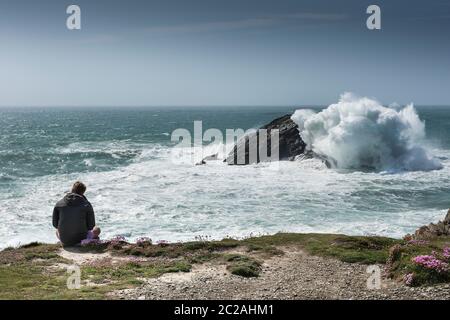 Ein Tourist, der die dramatische Aussicht von Pentire Point East an der Küste von Newquay in Cornwall genießt. Stockfoto