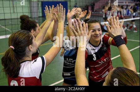 Junge weibliche Volleyball-Teamkollegen unterstützen sich gegenseitig, während eines Jugend-Volleyball-Finale, in Mailand. Stockfoto