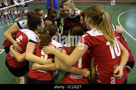 Junge weibliche Volleyball-Teamkollegen unterstützen sich gegenseitig, während eines Jugend-Volleyball-Finale, in Mailand. Stockfoto