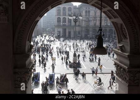 Blick von oben auf Fußgänger, die auf dem Duomo Platz laufen, durch die Galerie Arkade gesehen, in der Innenstadt von Mailand. Stockfoto