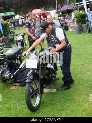 Ein älterer Mann und sein klassisches Motorrad im Park an der hebdenbrücke jährliches Vintage-Wochenende Stockfoto