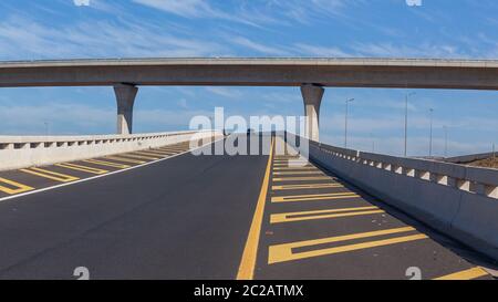 Straße Autobahn Ausfahrt Auffahrrampen und Überführung stehend Mitte der neuen Asphalt geteerten Strukturen für Pkw in blauen Himmel Panorama-Landschaft Stockfoto