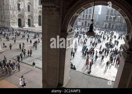 Blick von oben auf Fußgänger, die auf dem Duomo Platz laufen, durch die Galerie Arkade gesehen, in der Innenstadt von Mailand. Stockfoto