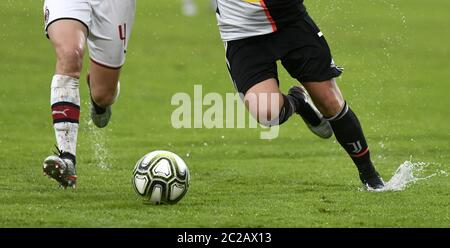 Nahaufnahme der Beine von weiblichen Fußballspielerinnen Aktion, auf einem nassen grünen Fußballfeld. Stockfoto