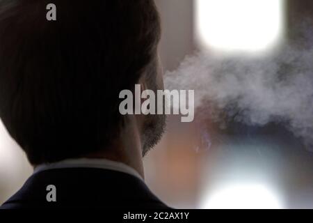 Mann, der von seinem Rücken aus raucht Stockfoto