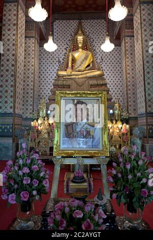 Berühmtes Foto von Thailands König, Vajiralongkorn, platziert unter einer goldenen Buddha-Statue, im Wat Arun Tempel, in Bangkok. Stockfoto