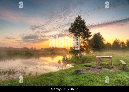 Für Picknick statt. Herbst bunte Sunrise auf nebligen ruhigen Fluss. Herbst Jahreszeit misty morning. Herbst Dämmerung Szene Panorama. Weißrussland Stockfoto