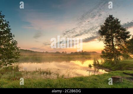 Herbst bunte Sunrise auf nebligen ruhigen Fluss. Herbst Jahreszeit misty morning. Herbst Dämmerung Szene Panorama. Weißrussland Stockfoto