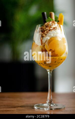 Bio Mango und Passionsfrucht tropische Eisbecher in Wein Glas Stockfoto