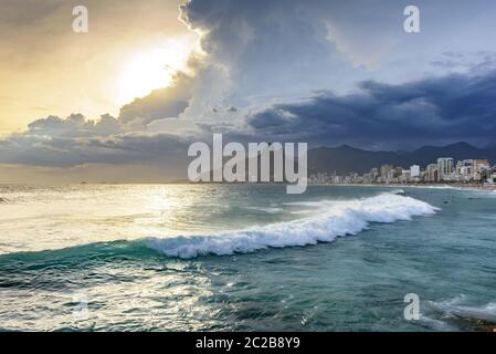 Wolkiger Sonnenuntergang mit Surfern am Strand von Ipanema Stockfoto