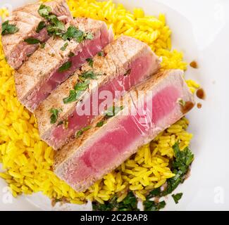 Ahi Thunfisch Steak mit gelber Reis und Kräuter Stockfoto