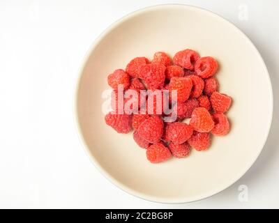 Eine Schüssel mit frischen Himbeeren von oben isoliert auf weißem Hintergrund mit Kopierraum auf der linken Seite Stockfoto