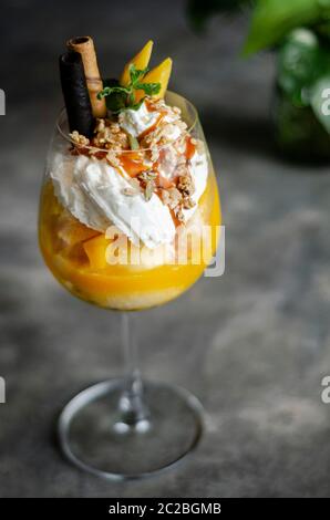 Bio Mango und Passionsfrucht tropische Eisbecher in Wein Glas Stockfoto