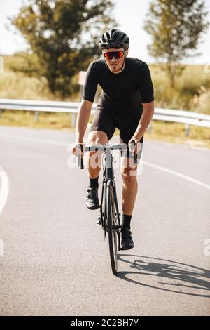 Bärtige reifen Mann in aktiven Verschleiß und Schutzhelm tun sportliche Aktivität auf dem Fahrrad. Starker Radfahrer in Spiegelbrille führt zu einem gesunden Lebensstil. Stockfoto