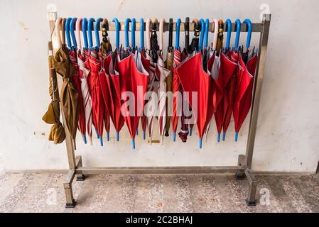 Rote Schirme hängen an der Reihe.viele Schirme hängen an weißen Schiene für die Menschen zu verwenden. Stockfoto