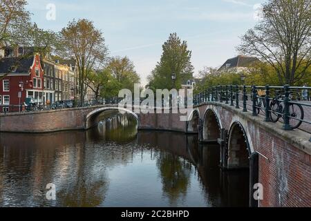 Eine der vielen Brücken über einen Kanal in Amsterdam Niederlande Stockfoto