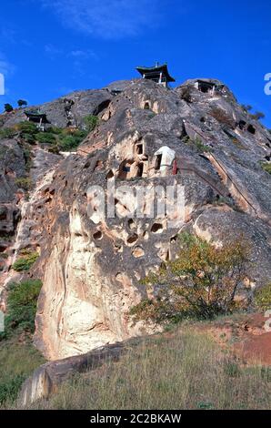 Blick auf die Xumishan Grotten, die auch als Xumi Shan oder Xumishan bezeichnet werden. Sie sind eine Sammlung von über 130 buddhistischen Höhlentempeln, die in eine rote Sandsteinklippe in der autonomen Region Ningxia Hui im Nordwesten Chinas gehauen wurden Stockfoto