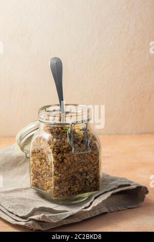 Gesundes Frühstück, Müsli, in einem hohen Glas auf einem rosa Hintergrund Stockfoto