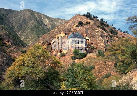 Blick auf die Xumishan Grotten, die auch als Xumi Shan oder Xumishan bezeichnet werden. Sie sind eine Sammlung von über 130 buddhistischen Höhlentempeln, die in eine rote Sandsteinklippe in der autonomen Region Ningxia Hui im Nordwesten Chinas gehauen wurden Stockfoto