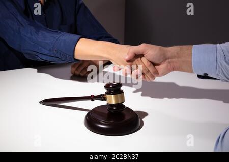 Close-up Mallet und Hammer vor Richter Händeschütteln mit seinem Client Stockfoto
