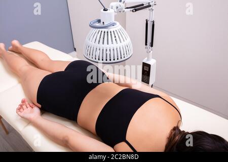 Arzneimittel Infrarot strahlenden Behandlung auf der Frau Rücken liegend auf dem Bett in der Medizinischen Klinik Stockfoto
