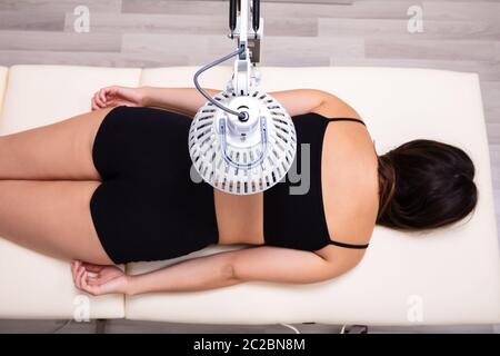 Arzneimittel Infrarot strahlenden Behandlung auf der Frau Rücken liegend auf dem Bett in der Medizinischen Klinik Stockfoto