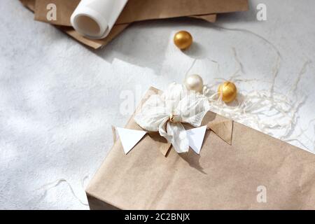 Flatlay Weihnachtskomposition aus Geschenkschachtel und Kraftpapier auf weißem Hintergrund. Hintergrund Der Feiertage. Stockfoto