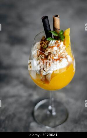 Bio Mango und Passionsfrucht tropische Eisbecher in Wein Glas Stockfoto