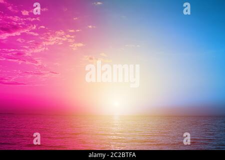 Kreative fluoreszierende Farbgestaltung aus Sonnenuntergang auf dem Meer. Natur und Sommer Konzept. Kopierbereich. Stockfoto