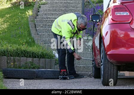 Ein Mann wechselt die Reifen an seinem Auto. Sommerreifen im Frühjahr wechseln Stockfoto