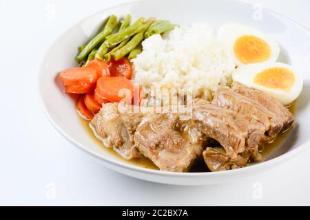 Gebackene Schweinerippchen mit Reis, gekochtes Ei und Gemüse Stockfoto