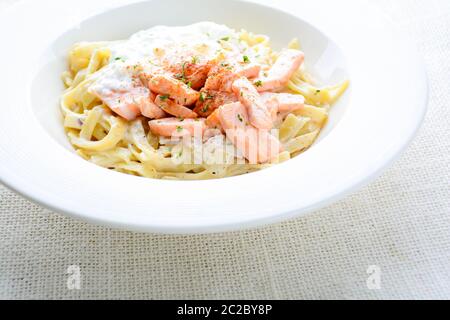 Fettucine mit Lachs, Ei und Parmesan, serviert auf weißem Teller.Fettucine mit Lachs, Ei und Stockfoto