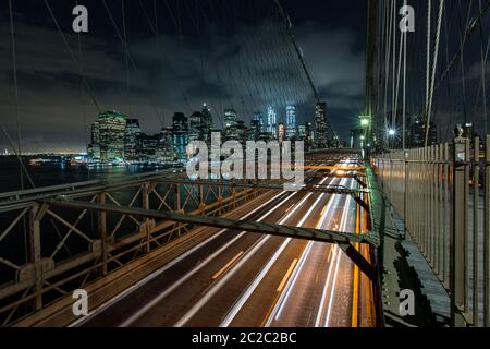 Dämmerung viel Verkehr über die Brooklyn Bridge und Lower Manhattan Skyline, New York, United States Stockfoto