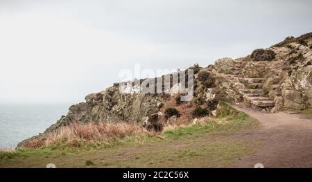 Wanderweg auf einer Klippe entlang dem Meer in Howth, Irland Stockfoto