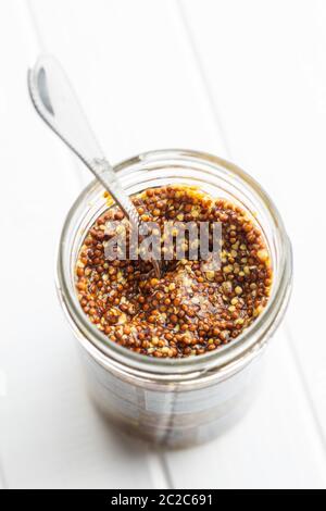 Ganze Senf im Glas auf weißer Tisch. Stockfoto