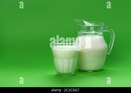 Glas und Glas Milch auf grünem Hintergrund mit Kopie Platz für Text isoliert, milchprodukt Konzept Stockfoto