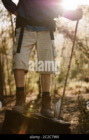 Low-Section-Aufnahme eines männlichen Wanderers, der keinen Stein mit einem Stock hält. Senior Mann Wandern in der Natur, eine Pause. Stockfoto